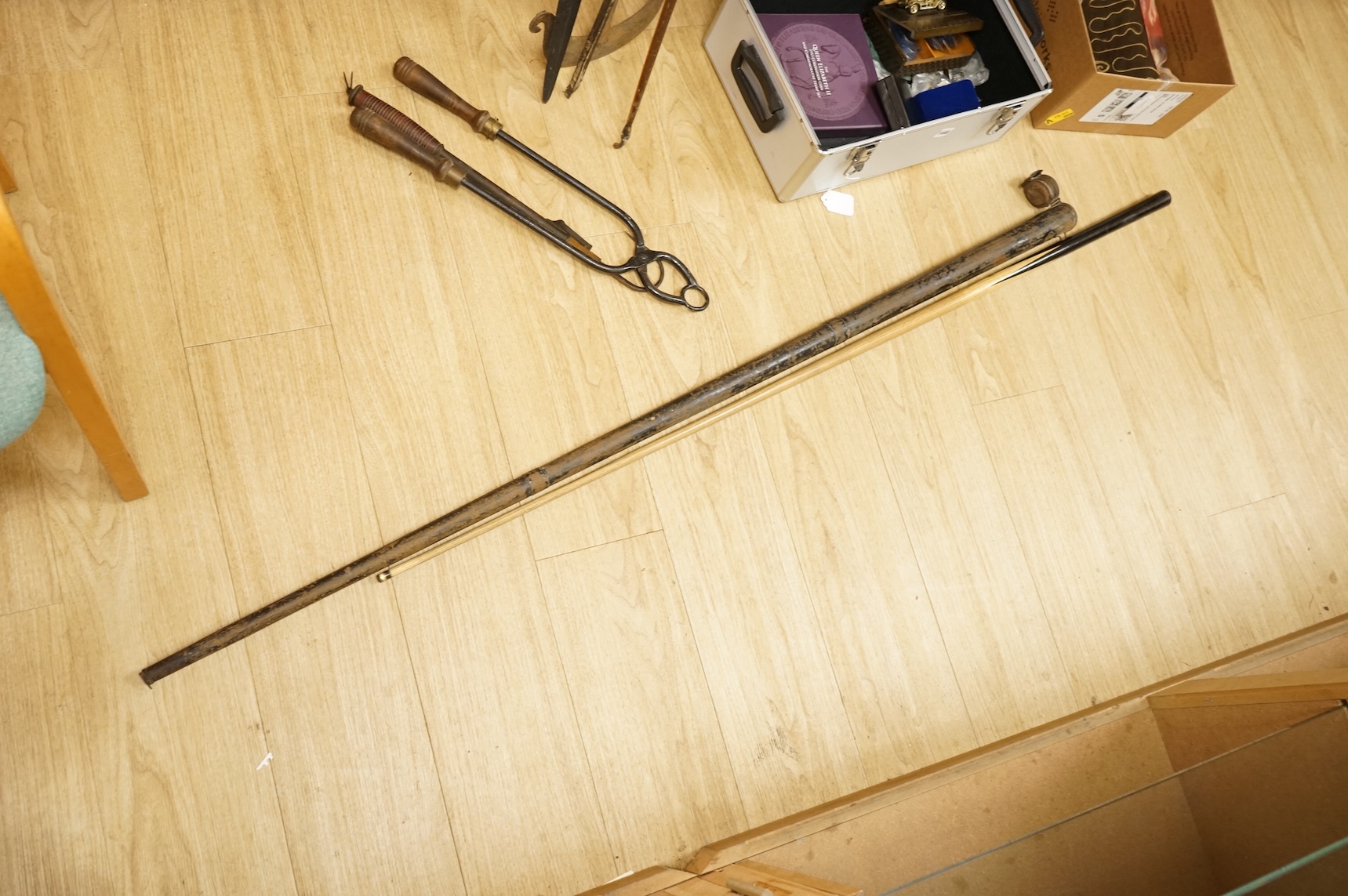 A collection of tribal spears, a fish hook, a cased snooker cue, etc.